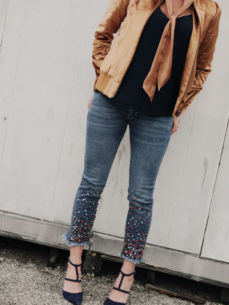 a gold jacket and blue heels and jeans